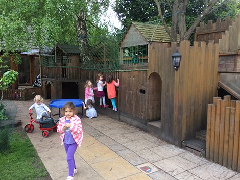 Feeding the lambs in the garden at Acorns Nursery School Cirencester