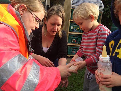 Feeding the lambs in the garden at Acorns Nursery School Cirencester