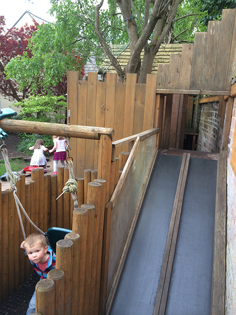 Feeding the lambs in the garden at Acorns Nursery School Cirencester